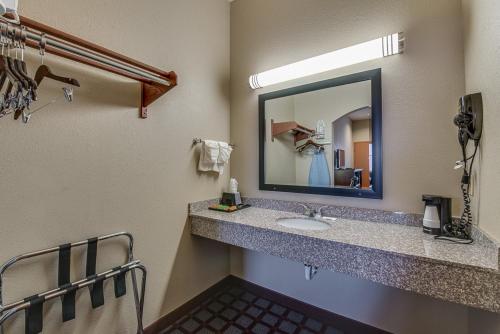 un baño con lavabo y espejo en Executive Inn & Suites Cushing, en Cushing