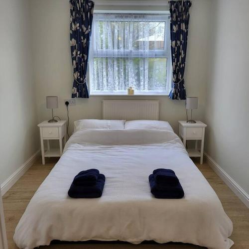 een slaapkamer met een groot bed en 2 blauwe handdoeken bij Cheerful one bedroom home with patio and parking in Newbury