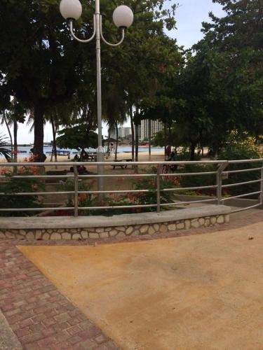 Un parque con una valla y flores y una farola. en Sandcastle apartments E9, en Ocho Ríos