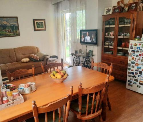 una cocina con una mesa de madera y un bol de fruta. en Landhaus Kate en Lusnić