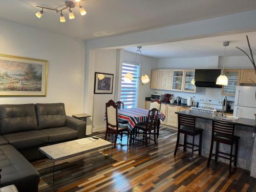 ein Wohnzimmer und eine Küche mit einem Sofa und einem Tisch in der Unterkunft Le 2316 in Saint-Hyacinthe