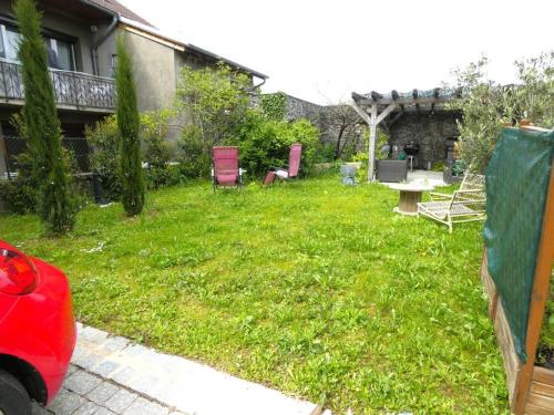 einen Garten mit Stühlen und einem Tisch im Hof in der Unterkunft Studio St Julien near Geneva in Saint-Julien-en-Genevois