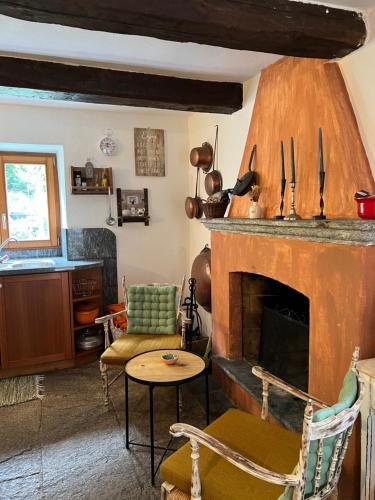 ein Wohnzimmer mit einem Kamin, einem Tisch und Stühlen in der Unterkunft Rusticus1706 in Lavertezzo