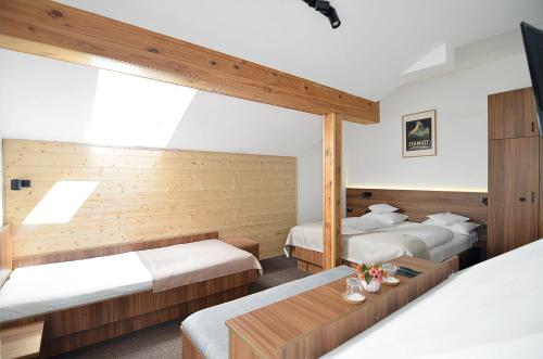 a hotel room with two beds and a table at Pensiune & Restaurant Victoria in Păltiniş