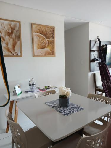 uma mesa branca com um vaso de flores em Apartamento Villa Giovanne em João Pessoa