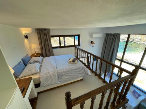 ein Schlafzimmer mit einem Bett und einem Balkon in der Unterkunft Hersonissos Andros in Gavrio