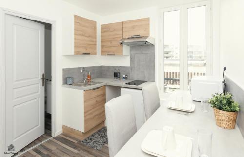 une cuisine blanche avec un évier et un comptoir dans l'établissement La résidence Jeanne d'Arc 5, Troyes - France, à Troyes