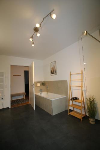 La grande salle de bains est pourvue d'une baignoire et d'un lavabo. dans l'établissement Hygge Homes - 3 Zimmer Apartment, barrierefrei mit Terrasse, à Scharmbeck
