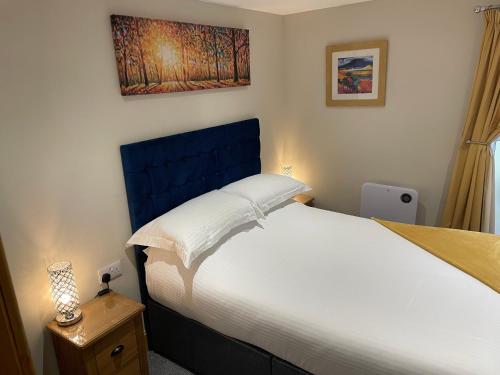 um quarto com uma cama grande e uma cabeceira azul em The Mews 2 bedroom with private parking em Oban