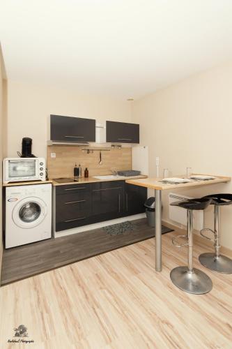 - une cuisine avec un comptoir, une table et une cuisinière dans l'établissement Les Jardins d'Hermès, à Troyes