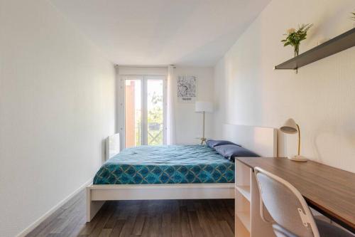 une chambre avec un lit, un bureau et une fenêtre dans l'établissement Appartement T2 Toulouse - 47m2 - Parking gratuit & wifi, à Toulouse