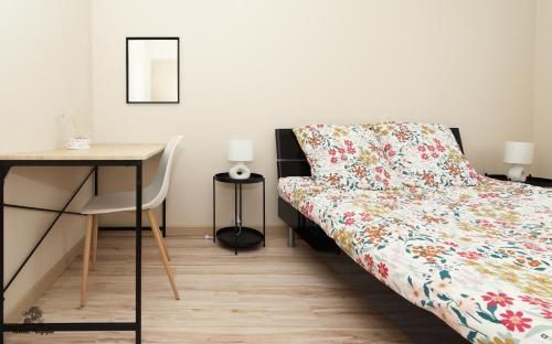 une chambre avec un lit, une table et un bureau dans l'établissement Les Jardins d'Hermès, à Troyes