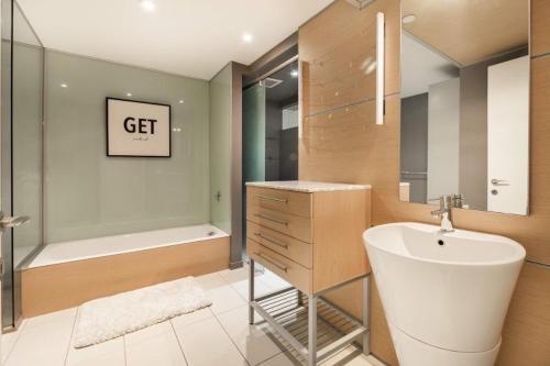 y baño con bañera, lavamanos y bañera. en Elegant apartment Vieux Port Montreal, en Montreal