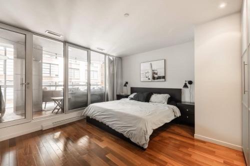 1 dormitorio con cama y ventana grande en Elegant apartment Vieux Port Montreal, en Montreal