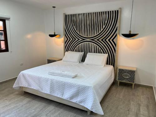 a bedroom with a white bed with two towels on it at Hotel Valledupar Plaza in Valledupar
