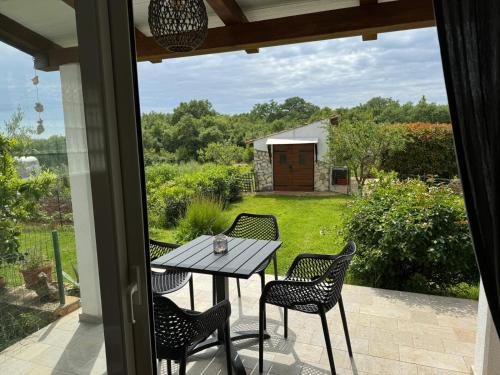 a table and chairs on a patio with a view of a yard at Apartaments Sanja Novigrad in Dajla