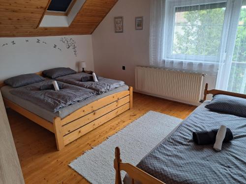 a bedroom with two twin beds and a window at Kismarosi Center Apartman in Kismaros