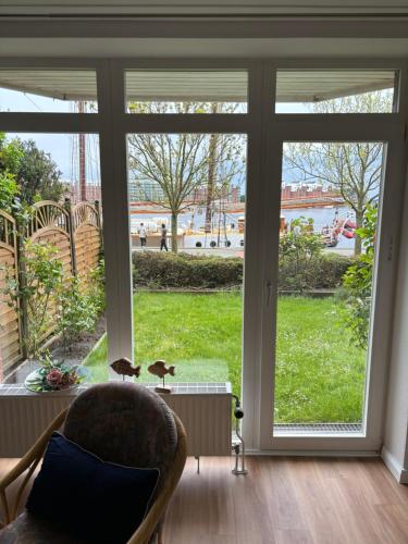 a living room with a large window looking out at a yard at Ferienwohnung Havenblick in Wilhelmshaven