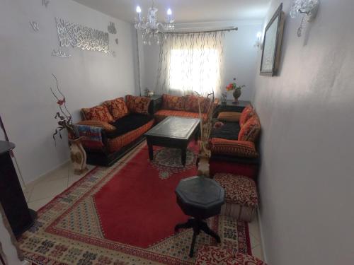 uma sala de estar com um sofá e uma mesa em Cosy apartement close to the AIRPORT em Tânger