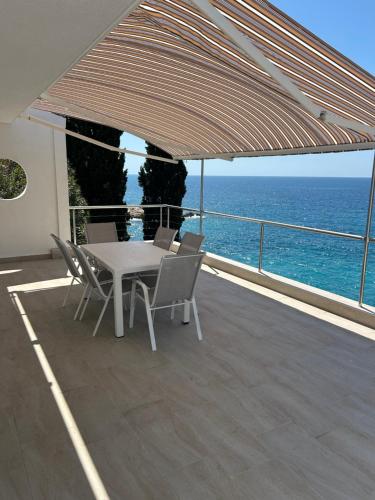 a patio with a table and chairs and the ocean at Resort Stikovic in Dobra Voda