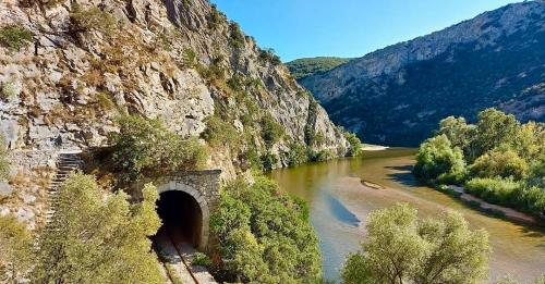 a tunnel in the side of a mountain next to a river at Sountou home in Xanthi