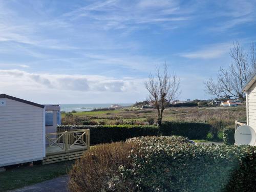 une maison blanche avec un portail dans une cour dans l'établissement location mobil home neuf, vue mer, tout confort, 6 personnes, à Saint-Jean-dʼOrbetiers