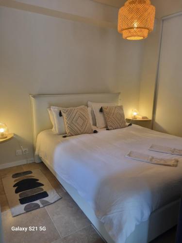 une chambre avec un grand lit blanc avec des oreillers dans l'établissement Escapade paisible au coeur du Luberon, à Grambois