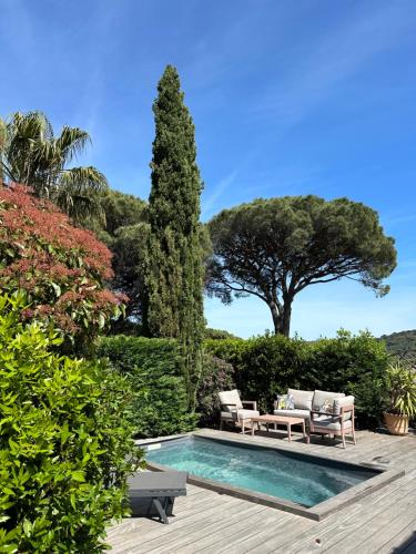 - une piscine avec 2 chaises, une table et un arbre dans l'établissement Loft Oasis - Grande terrasse et piscine, à Gassin