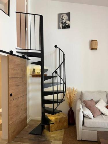 un escalier en colimaçon dans un salon à côté d'un canapé dans l'établissement Duplex chaleureux et élégant à deux pas de la mer, à Marseille