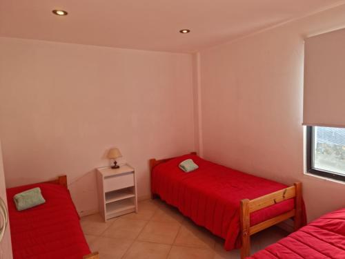 um quarto com 2 camas e uma janela em Departamento de 1 Dormitorio con Sala Estar em Rio Grande