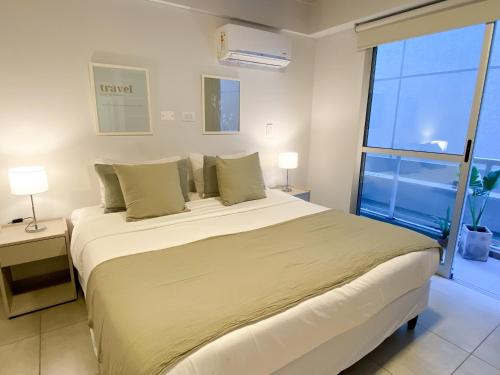 a bedroom with a large bed and a large window at Alfa Suites en el casco histórico de Salta in Salta