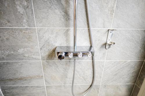 a shower with a hose in a bathroom at Cocoonhuts Résidences Martinique in Le Lamentin
