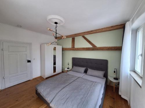 a bedroom with a large bed and a chandelier at Ferienhaus Altstadt in Bamberg