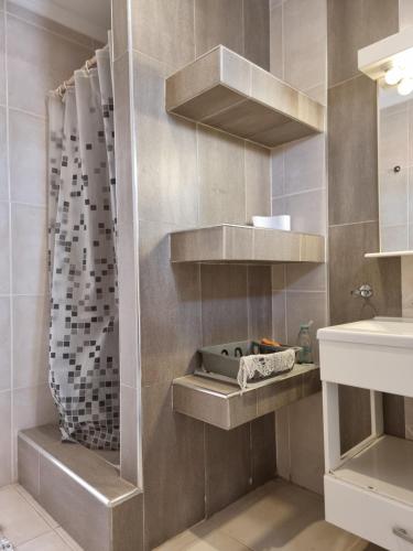 uma casa de banho com um lavatório e um chuveiro em Departamento de 1 Dormitorio con Sala Estar em Rio Grande