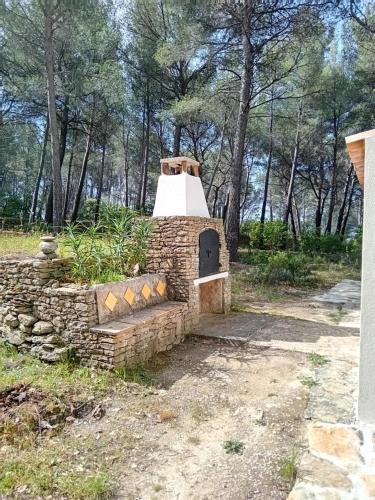 a stone oven in a field with trees in the background at La maison du rouquet in Le Beausset