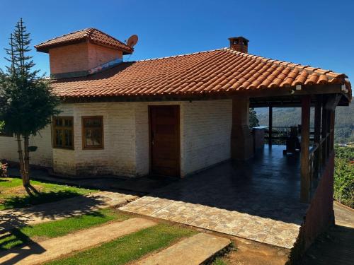 蒙特沃德的住宿－Casa Recanto Beija Flor, Monte Verde，屋顶上设有瓦屋顶的小房子