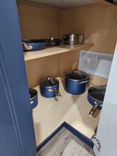 a kitchen with blue pots and pans on shelves at Poolside entire lower level apt in Whitby