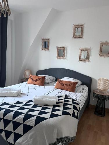 - une chambre avec un lit noir et blanc et des oreillers dans l'établissement Grande maison pêcheur. Centre ville Trouville, à Trouville-sur-Mer