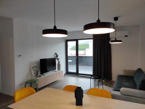 a living room with a table and a couch at Modern Apartment with great terasse and mountain view in Braşov