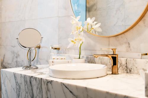 a bathroom with a sink and a mirror at Rooms Hotel in Jeddah