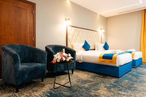 ein Hotelzimmer mit einem Bett und einem Stuhl in der Unterkunft Rooms Hotel in Dschidda