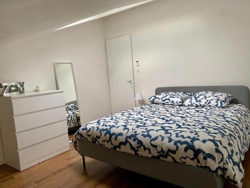 Schlafzimmer mit einem Bett, einer Kommode und einem Spiegel in der Unterkunft Duplex 1 chambre in Chalamont