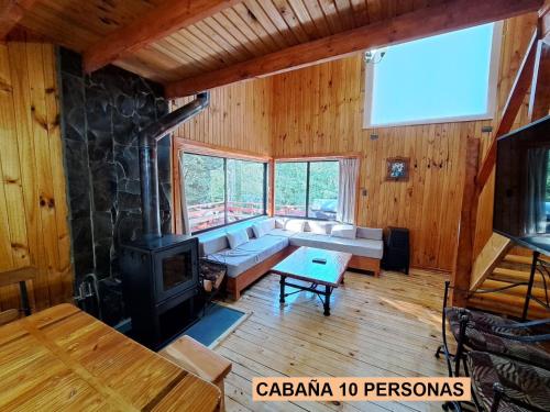 a living room with a couch and a stove at Cabaña las trancas in Nevados de Chillan