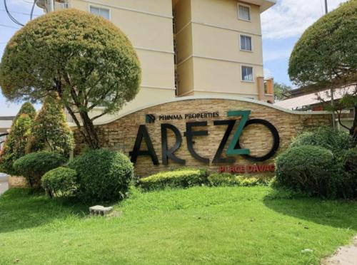 a sign in front of a building at REI Condotel Arezzo place Davao in Davao City