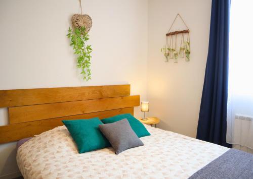 een slaapkamer met een bed met een houten hoofdeinde bij Studio'Moment Saint-Omer Centre in Saint-Omer