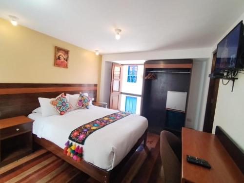una camera d'albergo con letto e TV di Casablanca lodge a Ollantaytambo
