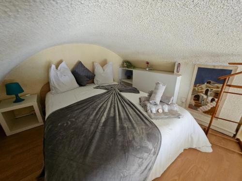 une chambre avec un lit avec une couette noire et blanche dans l'établissement Le Bellevue YourHostHelper, à Gruissan