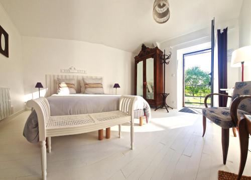 フレエルにあるLa Fontaine de Resnelの白いベッドルーム(ベッド1台、椅子付)