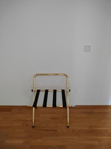 een metalen stoel bovenop een houten vloer bij Garden View Triple Room - Neusiedlersee in Breitenbrunn