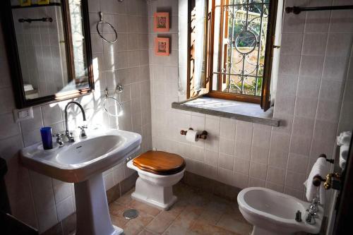 a bathroom with a sink and a toilet and a window at Casale Il Mulino con piscina Viterbo Bagnoregio in Celleno